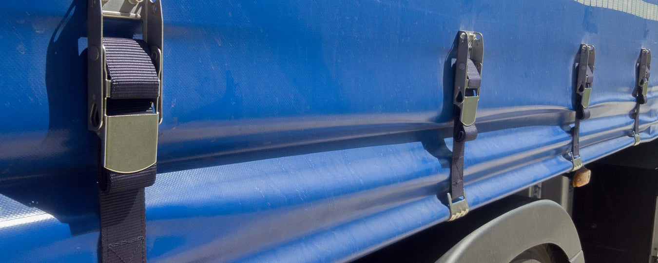 image showing a close-up of a blue vehicle using black taut straps
