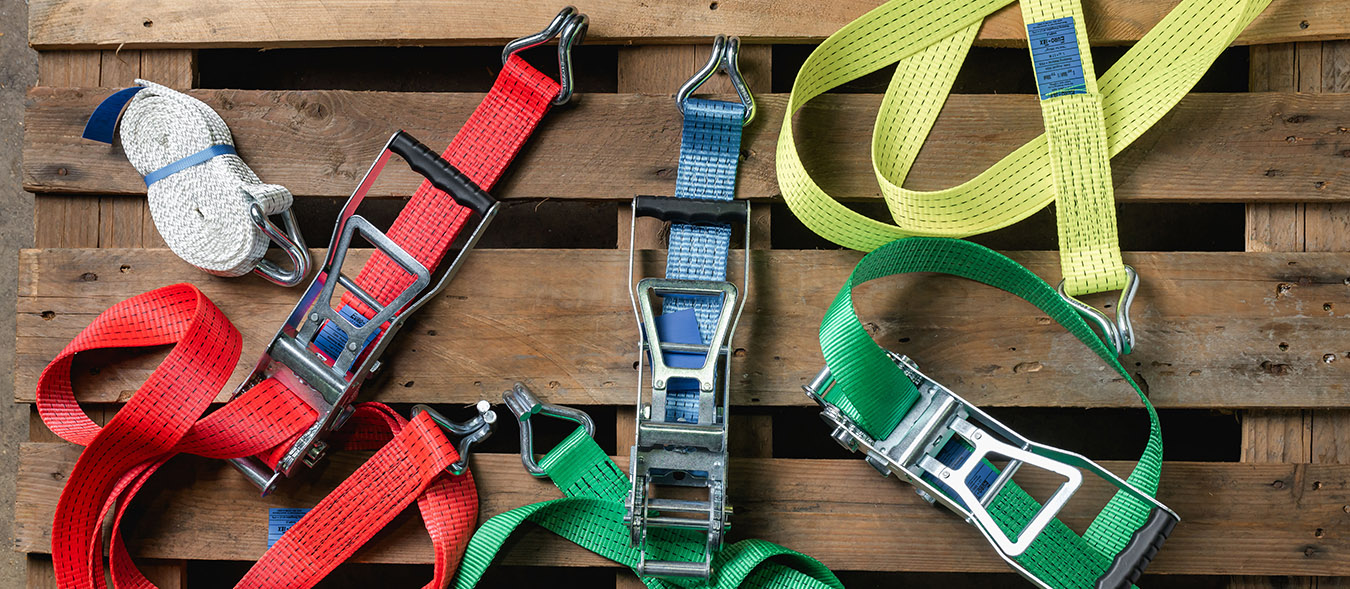 yellow, blue and orange taut straps securely fastened next to each other with silver buckles 